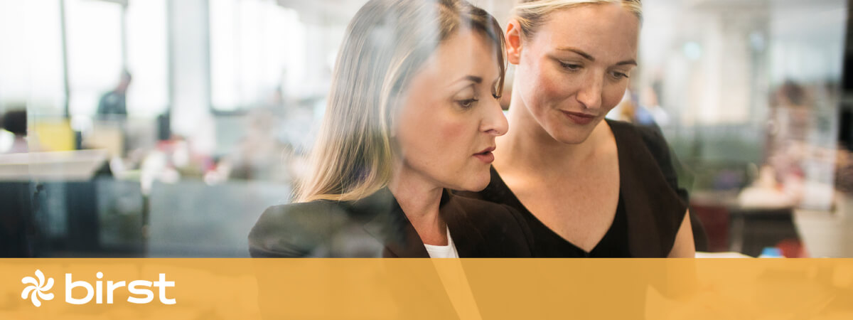 Two business women reviewing reports