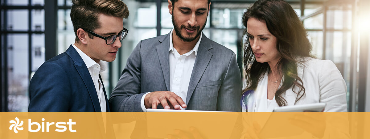 Three business people reviewing a report on an ipad